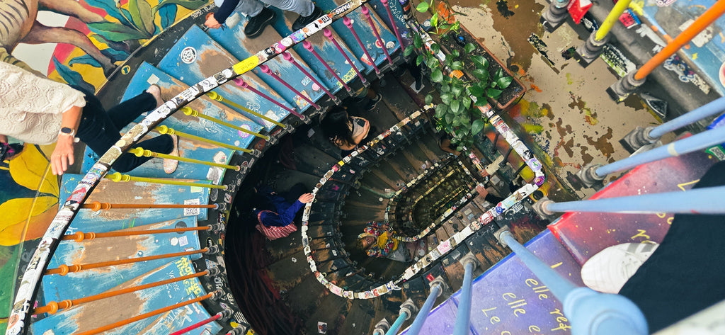 Colourful staircase inside 59 Rivoli in Paris, an artist-collective building filled with murals and creativity.